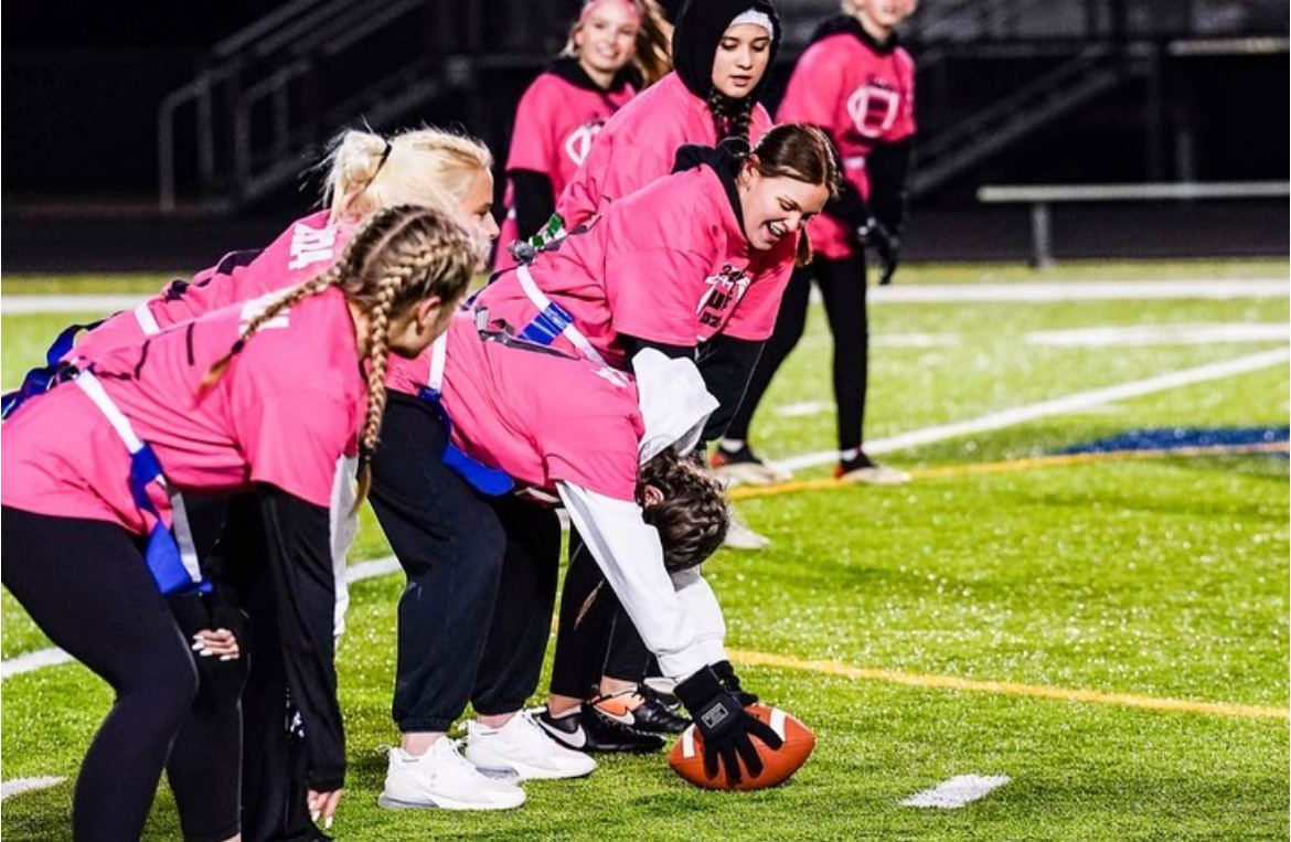 Senior girls set up on the line of scrimmage ready to hike the ball to their quarterback. Photo provided by Mackenzie Sonak.