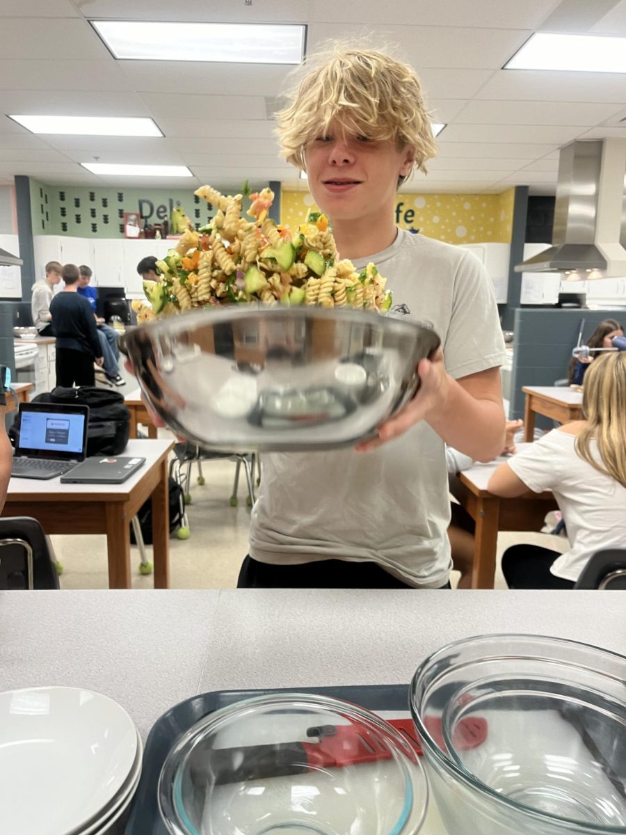 Freshman Jack Fraine tosses pasta salad. Photo provided by Ashley Rayburn. 