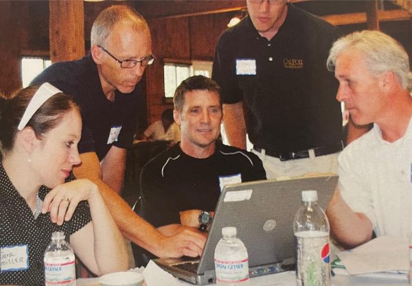 Science teachers Sara Miller, Scott Fortney, Steve Pyle, and other staff members learning how to use laptops at the staff retreat. Photo taken from the 2010-2011 yearbook.