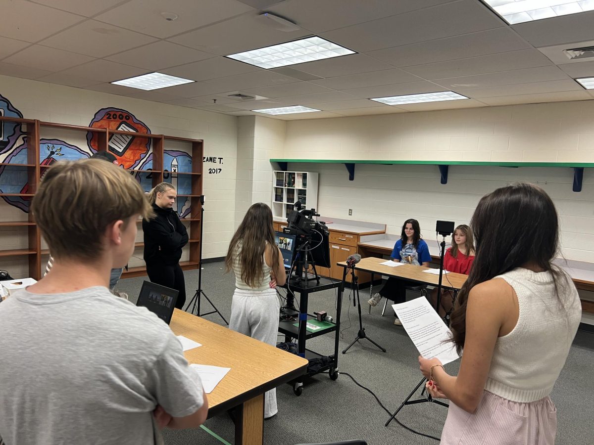 Pictured from left to right: sophomore Will Preston, junior Ainsley Bowman, sophomore Addie Clarke, senior Lilly Pratt, sophomore Aspen Ortiz, and senior Madyson Blizzard work together to make an episode of Wake Up Woodgrove. Photo provided by Chelsea Dyke.