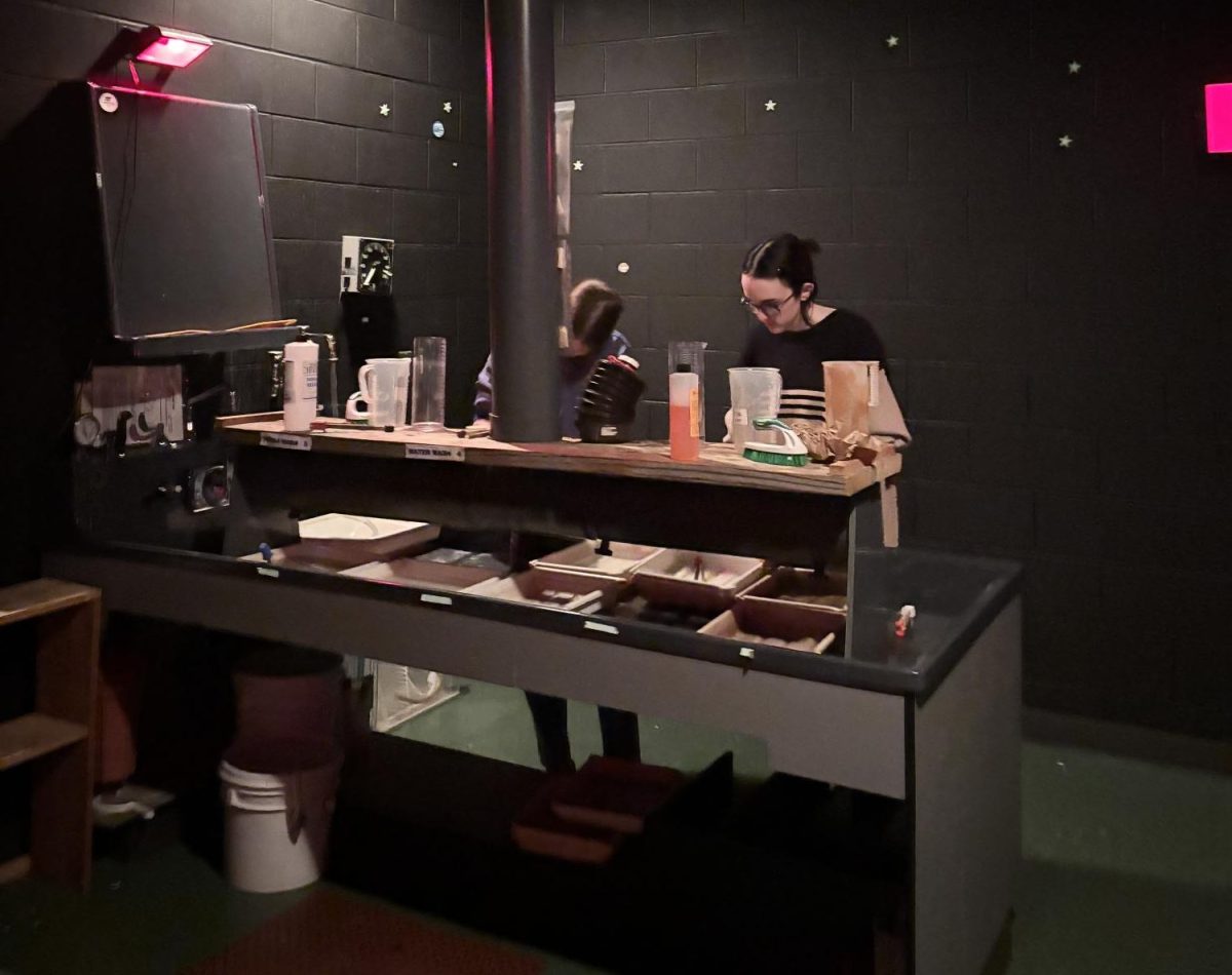 From left to right, sophomores Lilly Greer and Ren Nash work in the dark room. Photo provided by Delila Norris. 