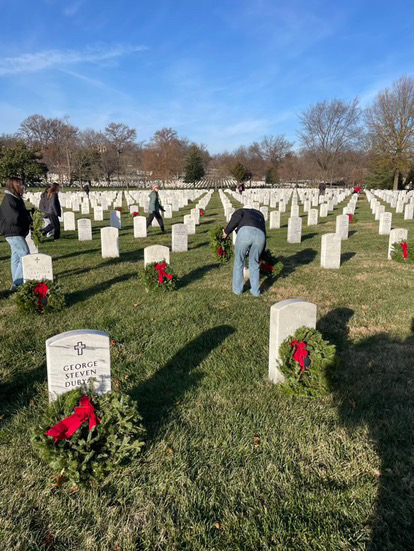 Rho Kappa student placing a wreath on a headstone. Photo provided by WHS Rho Kappa. 