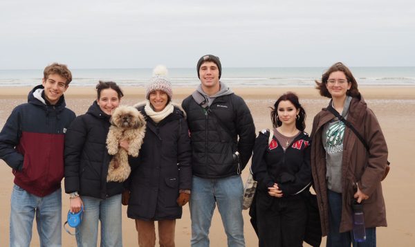 Seniors Patrick Lyons, Sarah Putorti, and Kennedy Dehler with a host family at Omaha Beach. Photo provided by Patrick Lyons.