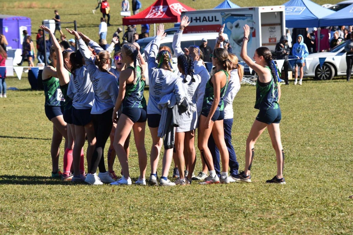 Freshman Taylor Nishiyama takes part in a team cheer during cross country season. Photo provided by Emilie Wall.