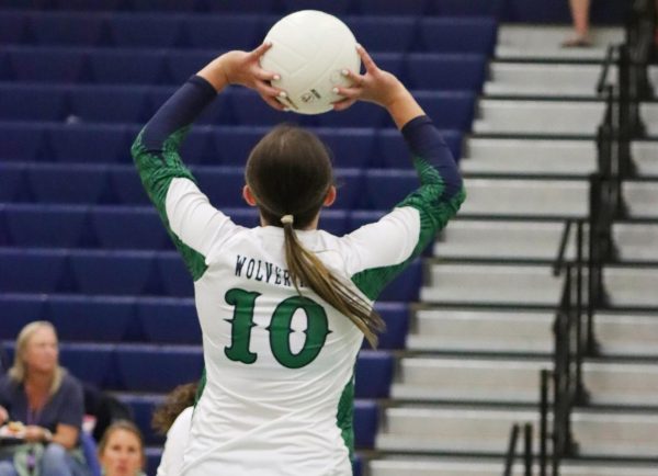 Reese Allen jumping to set a volleyball in the setter position on the Woodgrove Varsity Volleyball team. Photo provided by Legacy Studio. 